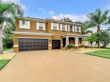 Two story house with brown exterior and a three car garage at 8809 49Th E Ave, Palmetto, FL 34221
