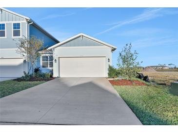 Light blue two-story house with a white garage door and landscaping at 9136 Gulf Haven Dr, Parrish, FL 34219