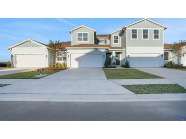Two-story townhome with light blue exterior, two-car garage, and landscaping at 9144 Gulf Haven Dr, Parrish, FL 34219