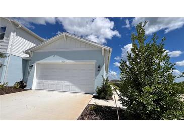 Two-car garage with white doors and light blue exterior at 9222 Gulf Haven Dr, Parrish, FL 34219