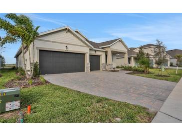 Two-story house with a three-car garage and a nicely landscaped front yard at 7474 Sea Manatee St, Parrish, FL 34219