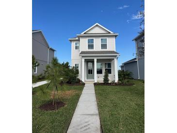 Charming two-story home with a well-manicured lawn, walkway, and covered entryway at 9031 Duany Ln, Lakewood Ranch, FL 34240