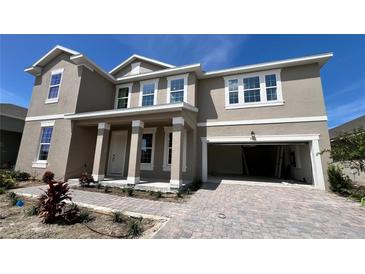 Two-story house with a neutral color scheme and a three car garage at 7446 Sea Manatee St, Parrish, FL 34219