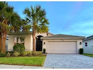 Two-story home with attached garage and landscaping at 5013 Sevilla Shores Dr, Wimauma, FL 33598