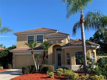 Inviting two-story home featuring lush landscaping, a tile roof, and a charming front entrance at 5271 Visionary Ct, Sarasota, FL 34233