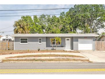 Charming single-story home with a well-maintained lawn, garage, and inviting front entrance, with shade trees overhead at 5330 Dr Martin Luther King Jr St S, St Petersburg, FL 33705