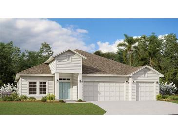 Charming single-Gathering home boasts a blue door, three-car garage and lush landscaping at 9608 Brave Buck Ave, Land O Lakes, FL 34638