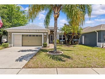 Charming single-story home featuring a well-manicured lawn and an attached two-car garage at 14820 Potterton Cir, Hudson, FL 34667