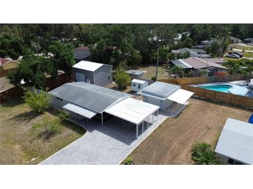 Expansive aerial view of home highlighting pool, carport, and additional storage outbuilding at 4125 Worcester Rd, Sarasota, FL 34231
