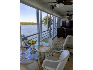 Bright dining area featuring a glass table and chairs with expansive windows offering stunning waterfront views at 4310 Falmouth Dr # 301, Longboat Key, FL 34228