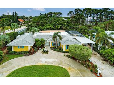 Stunning home with circular driveway, lush landscaping, and charming water fountain centerpiece at 401 Sunset Dr, Venice, FL 34285