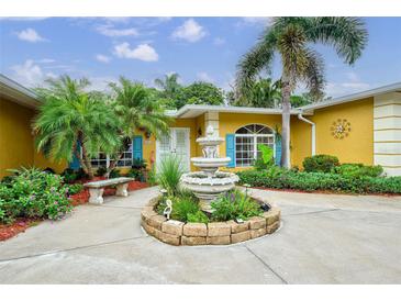 Charming home featuring a front yard with lush landscaping, a fountain, and a sitting bench at 401 Sunset Dr, Venice, FL 34285