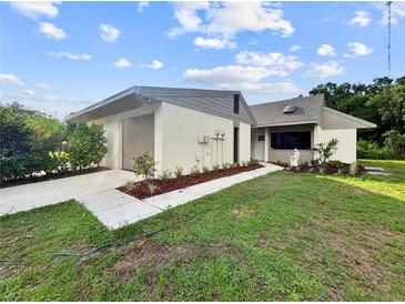 Charming single-story home featuring a well-manicured lawn and an attached garage with a neutral color palette at 5136 Cedar Hammock Dr, Sarasota, FL 34232