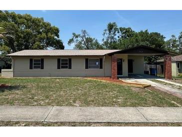 Charming single-story home with neutral siding, a covered carport, and a well-maintained front yard at 7169 Holiday Dr, Spring Hill, FL 34606