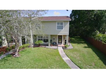 Two-story home featuring a well-manicured lawn, trimmed bushes, and a sidewalk to the front door at 15515 Morning Dr, Lutz, FL 33559