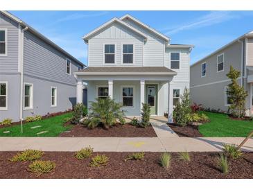 Charming two-story home with covered porch, landscaped front yard and light blue exterior at 130 Bragg Ln, Lakewood Ranch, FL 34240