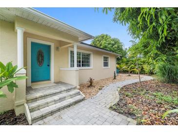 Tan house with teal door and landscaped walkway at 1701 38Th Ave, St Petersburg, FL 33713