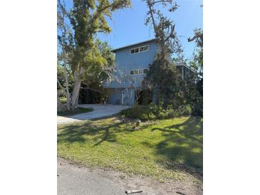 Blue two story home featuring mature landscaping and a concrete driveway, exuding curb appeal at 1612 Pocatello St, Sarasota, FL 34231