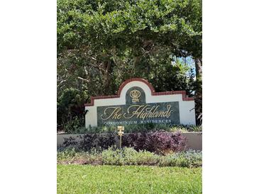 A welcoming entrance sign for The Highlands Condominium Residences amidst lush greenery at 9481 Highland Oak Dr # 715, Tampa, FL 33647