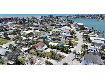 Wide aerial shot showcases a coastal neighborhood with waterfront access and diverse home styles at 13116 Boca Ciega Ave, Madeira Beach, FL 33708