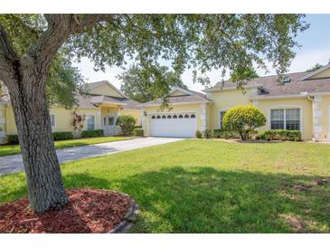 Charming single-story home with well-manicured lawn, mature tree, and a two-car garage at 1188 Royal Blvd, Palm Harbor, FL 34684