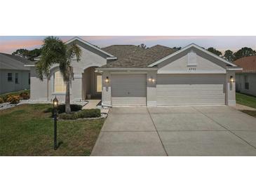 Charming home featuring a three car garage, well manicured lawn, and an inviting front entrance at 6335 Cardinal Crest Dr, New Port Richey, FL 34655