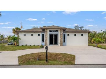 Stunning single-story home featuring a modern exterior, fresh landscaping, and a spacious driveway at 5479 S Biscayne Dr, North Port, FL 34287