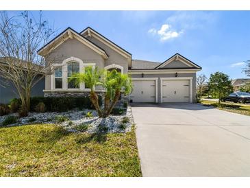 Charming single-story home with a manicured lawn, white rock landscaping, and a two-car garage at 13201 Orca Sound Dr, Riverview, FL 33579