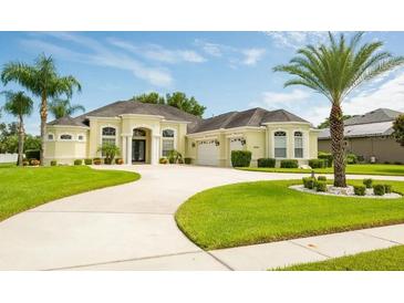 Charming single-story home with a beautiful lawn, circular driveway, and well-maintained landscaping at 14041 Bassingthorpe Dr, Spring Hill, FL 34609