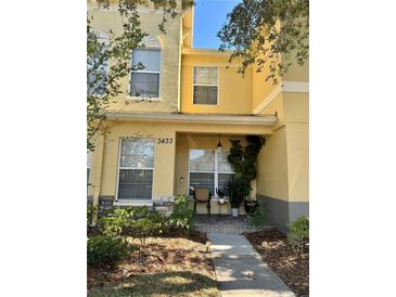 Inviting front exterior of a two-story townhome with a small porch and landscaping at 3433 Dragon View Ct, Valrico, FL 33594
