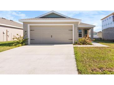 House exterior featuring a two-car garage and well-manicured lawn at 6832 Pebblebrooke Way, Zephyrhills, FL 33541