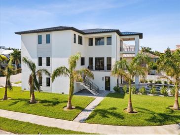 Modern home exterior with palm trees and landscaped lawn at 116 Wimbledon Ct, Redington Shores, FL 33708