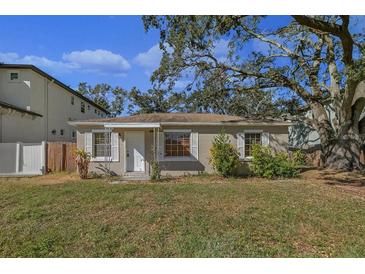 Tan house with a spacious lawn and mature trees at 4317 S Trask St, Tampa, FL 33611