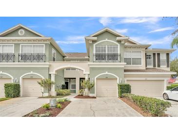 Charming townhome with a well-manicured lawn and a two-car garage with beige paint at 2151 Park Crescent Dr, Land O Lakes, FL 34639