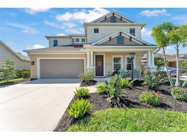Charming two-story home with a well-manicured lawn and inviting front porch at 7048 White Willow Ct, Sarasota, FL 34243