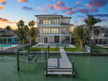 Waterfront home featuring a private boat dock and a backyard pool, perfect for enjoying waterfront living at 820 Bay Point Dr, Madeira Beach, FL 33708