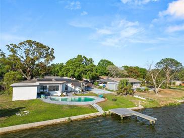 Stunning waterfront property with a private pool, dock, and lush landscaping at 5104 Saint Charles Pl, Tampa, FL 33610