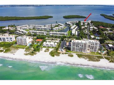 Stunning aerial view of beachfront condos with lush landscaping and beautiful water views at 605 Sutton Pl # 102, Longboat Key, FL 34228
