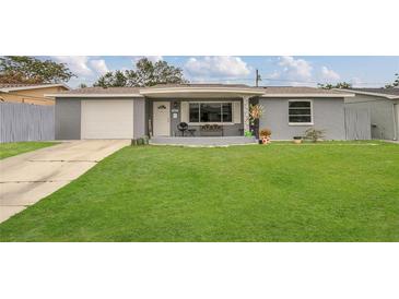 Inviting single-story home featuring a well-kept lawn and a cozy front porch at 3432 Monticello St, Holiday, FL 34690