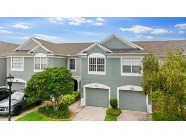 Inviting townhome with attached garages, complemented by well-maintained landscaping and a serene sky view at 2125 Wild Grape Pl, Riverview, FL 33578