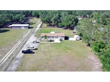 Expansive lot featuring a charming single-story home, shed, and ample parking surrounded by lush greenery and a private driveway at 8318 Franklin Rd, Plant City, FL 33565