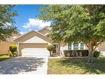 Charming single-story home with a well-maintained lawn, mature trees, and a two-car garage at 14385 Saltby Pl, Spring Hill, FL 34609
