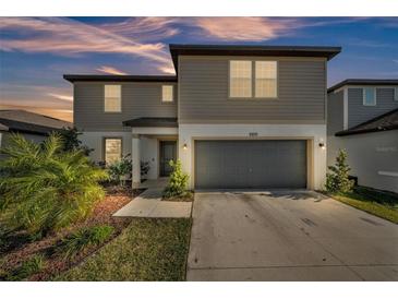 Charming two-story home with neutral siding, a two-car garage, and well-maintained landscaping at 1009 Golden Shiner Ave, Ruskin, FL 33570