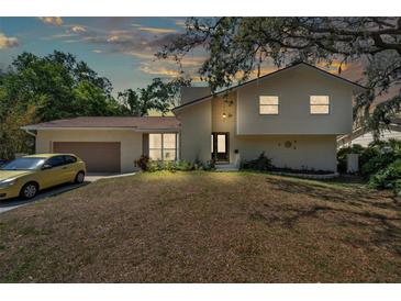 Charming two-story home featuring a well-manicured lawn and attached garage, exuding curb appeal at 114 Windy Pl, Brandon, FL 33511