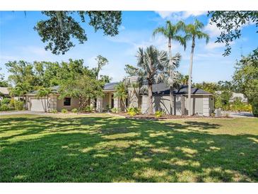 Inviting single-story home with lush lawn, mature trees, and neatly manicured landscaping at 7313 Crape Myrtle Way, Sarasota, FL 34241