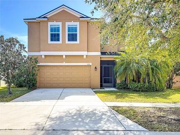 Charming two-story home with a well-manicured lawn, two-car garage, and inviting front entrance at 1401 Parker Den Dr, Ruskin, FL 33570