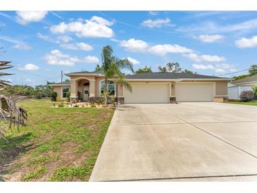 Inviting single-story home with a spacious three-car garage and well-manicured front yard at 11447 Adelia St, Spring Hill, FL 34608
