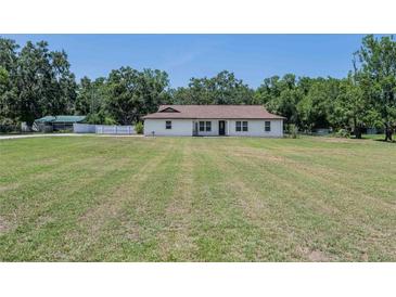 Charming single-story home featuring a bright, white exterior with a sprawling, green lawn at 7608 Franklin Rd, Plant City, FL 33565