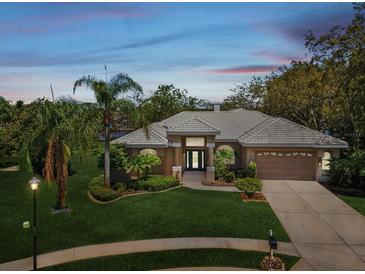 Charming single-story home featuring lush landscaping and a well-manicured lawn at 5903 Cachette De Riviera Ct, New Port Richey, FL 34655