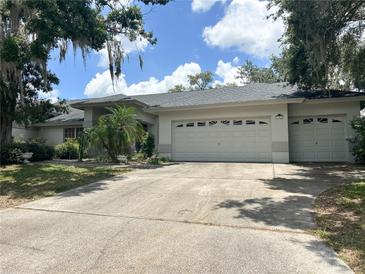 Charming single-story home with a spacious driveway and a two-car garage, complemented by lush landscaping at 1909 Masters Way, Plant City, FL 33566